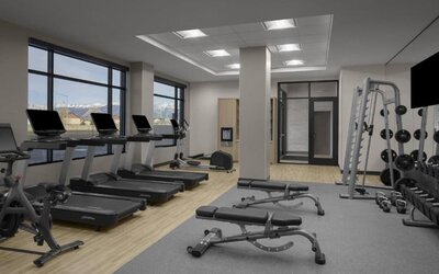 Fitness center with treadmills, free weights, benches, and strength training equipment at Hyatt Place Bozeman Yellowstone Airport.