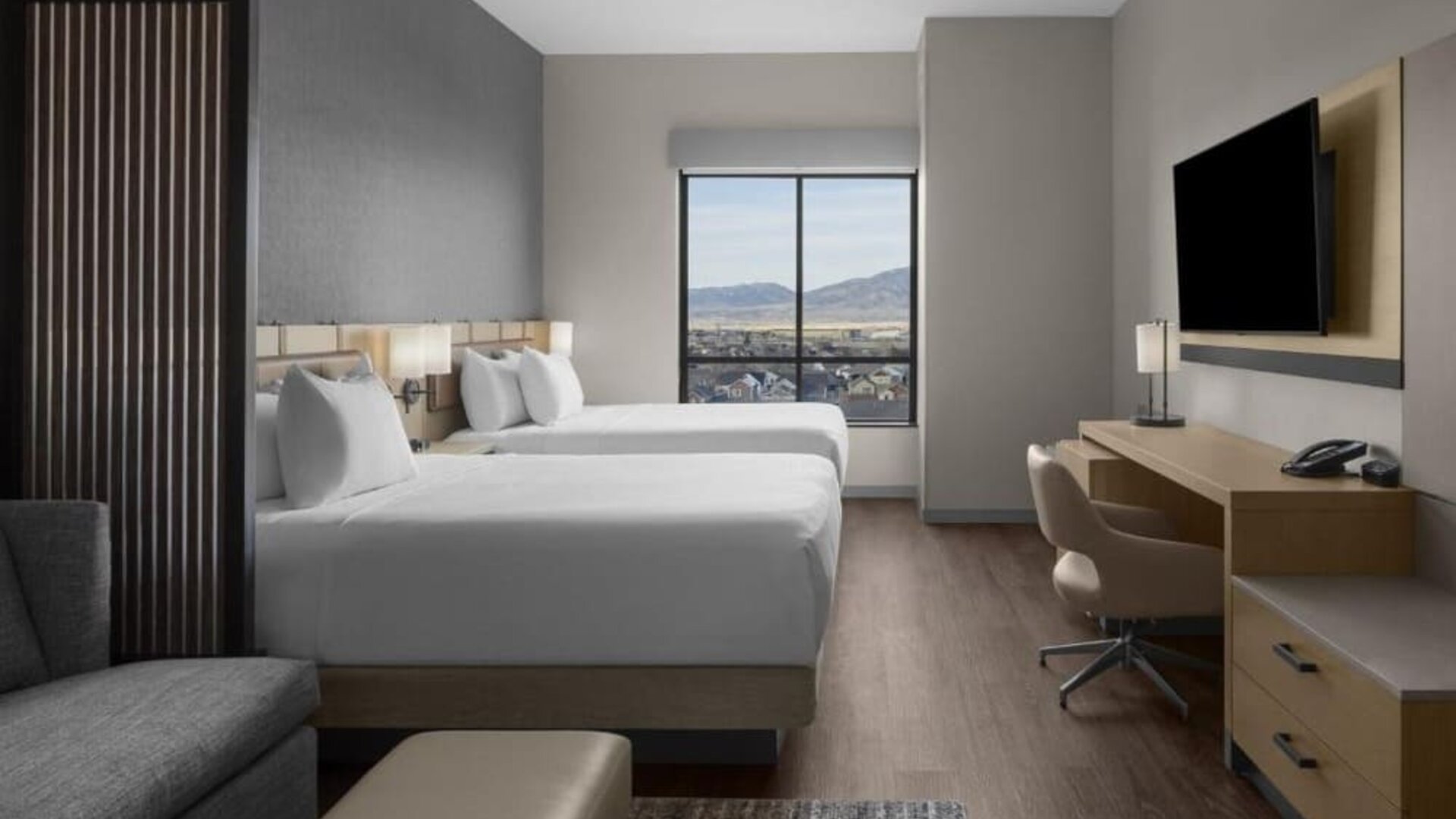 Guest room with two queen beds, work desk, sofa, and scenic mountain views at Hyatt Place Bozeman Yellowstone Airport.