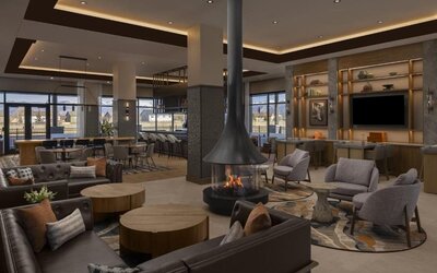 Spacious lobby with fireplace, lounge seating, bar area, and contemporary décor at Hyatt Place Bozeman Yellowstone Airport.
