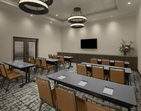 Meeting room with classroom-style seating, wall-mounted television, and flexible event space at Hyatt Place Bozeman Yellowstone Airport.
