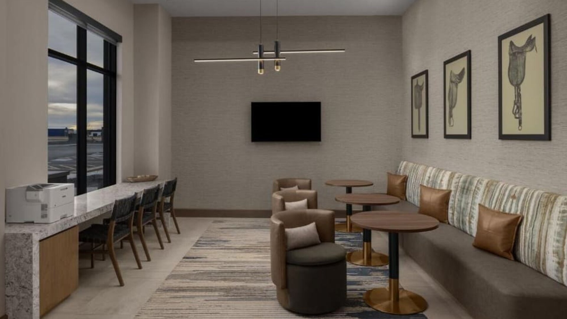 Business lounge with workstations, lounge seating, and wall-mounted television at Hyatt Place Bozeman Yellowstone Airport.