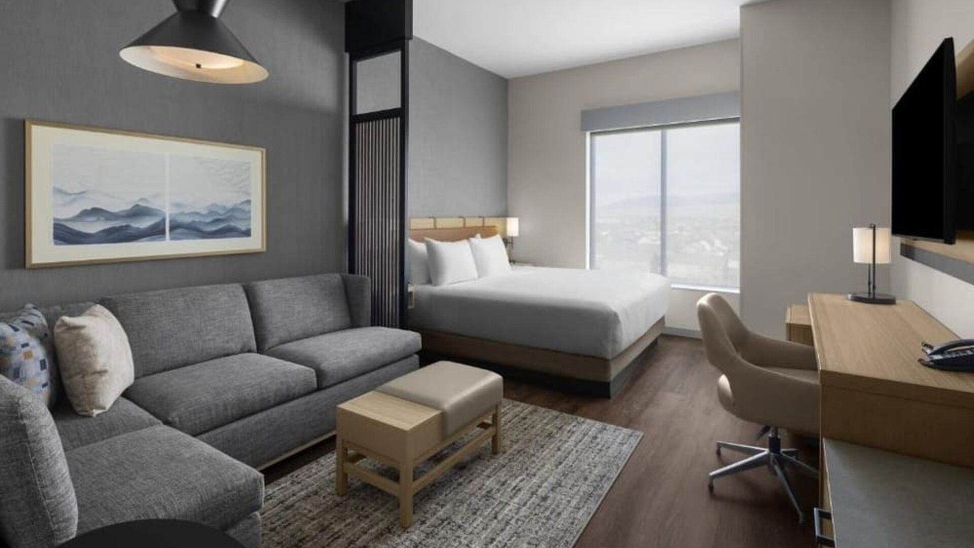Spacious king guest room with sofa, work desk, and modern furnishings at Hyatt Place Bozeman Yellowstone Airport.