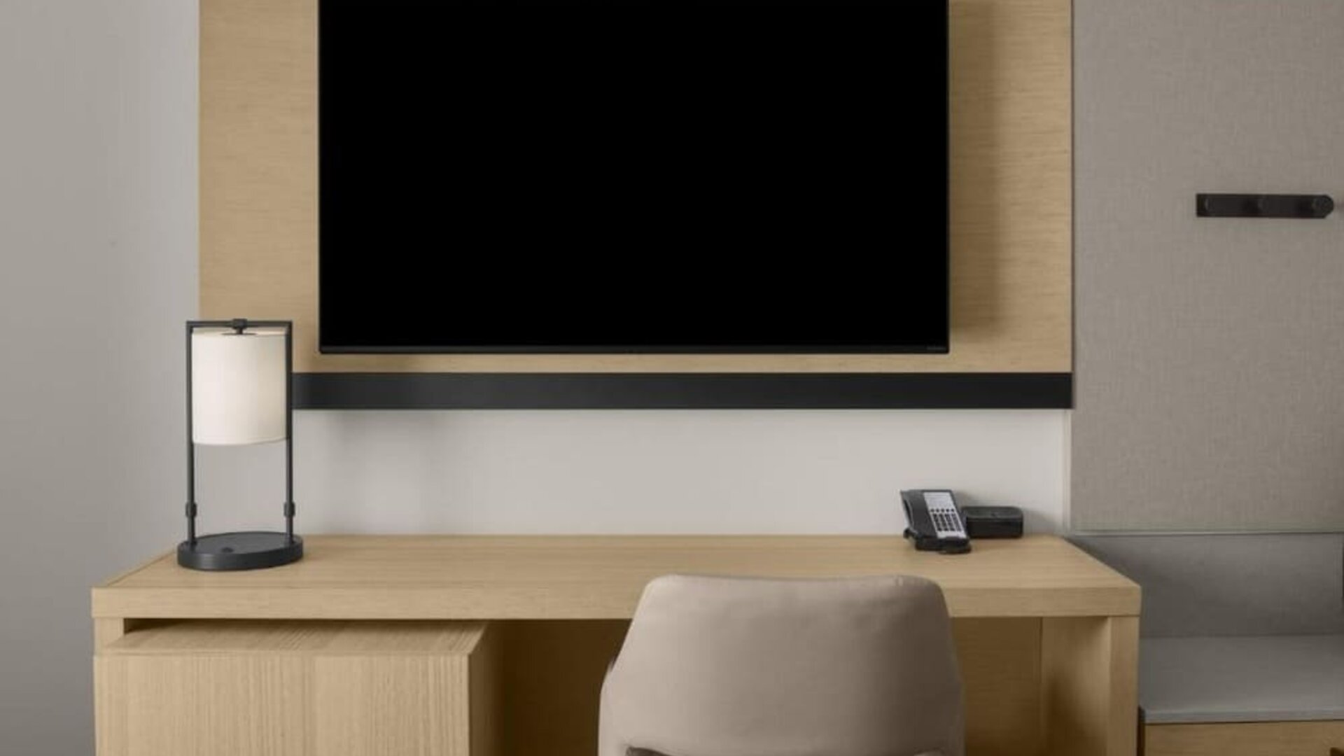 In-room workspace with desk, chair, telephone, and wall-mounted television at Hyatt Place Bozeman Yellowstone Airport.