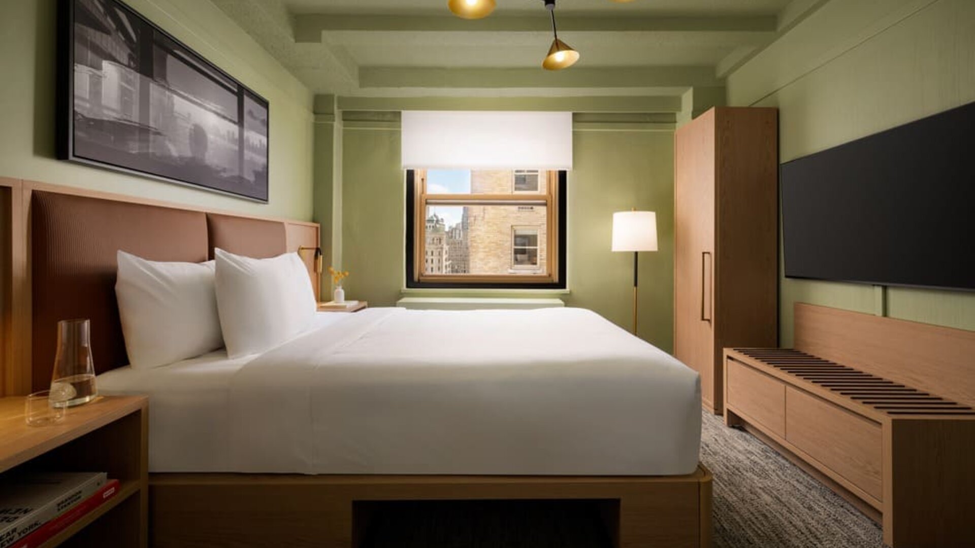 Cozy guest room with natural light, city views, and minimalist modern furnishings at Row NYC.