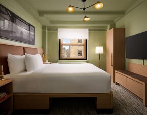 Cozy guest room with natural light, city views, and minimalist modern furnishings at Row NYC.