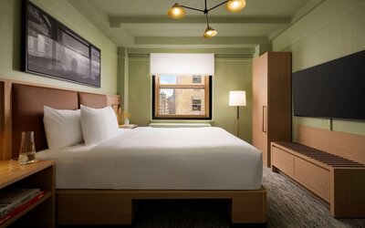Cozy guest room with natural light, city views, and minimalist modern furnishings at Row NYC.