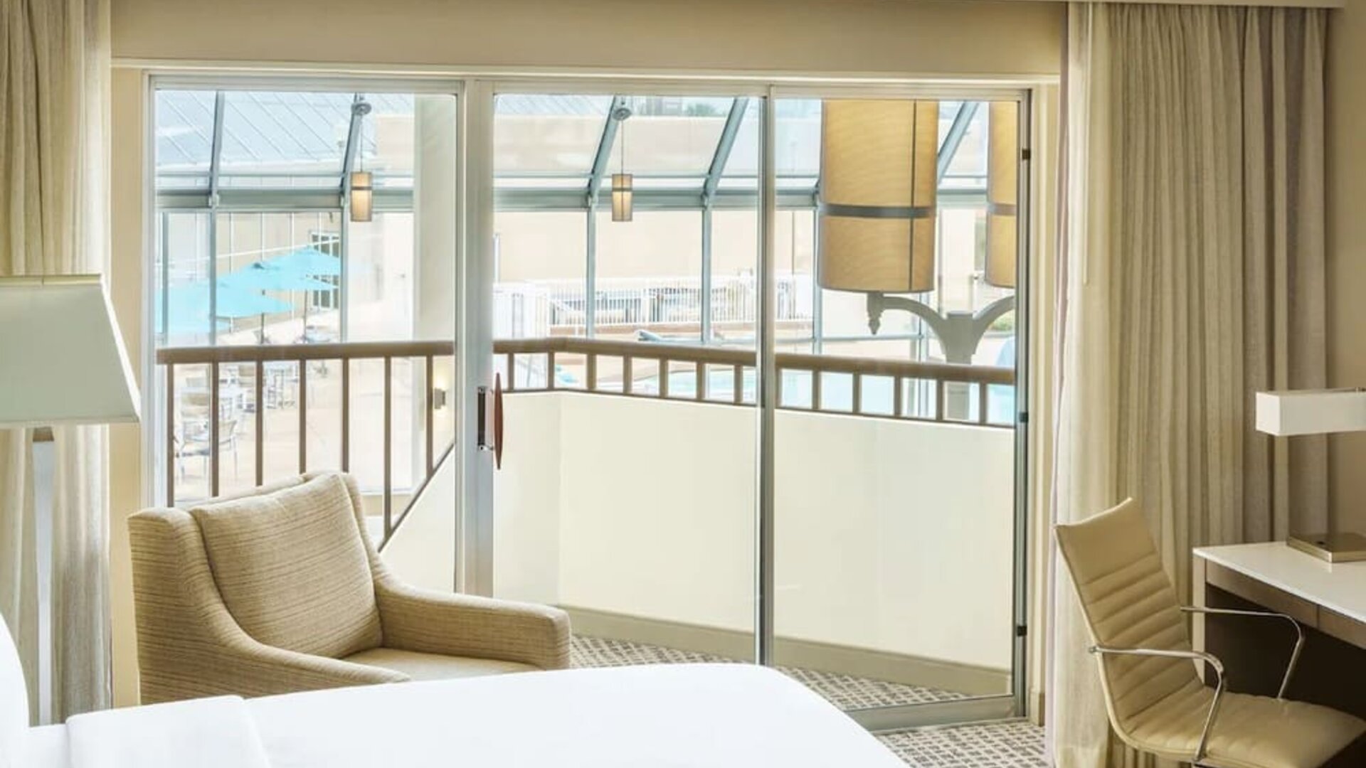 Spacious king room with plush bed, work desk, lounge chair, large window, and scenic outdoor view.