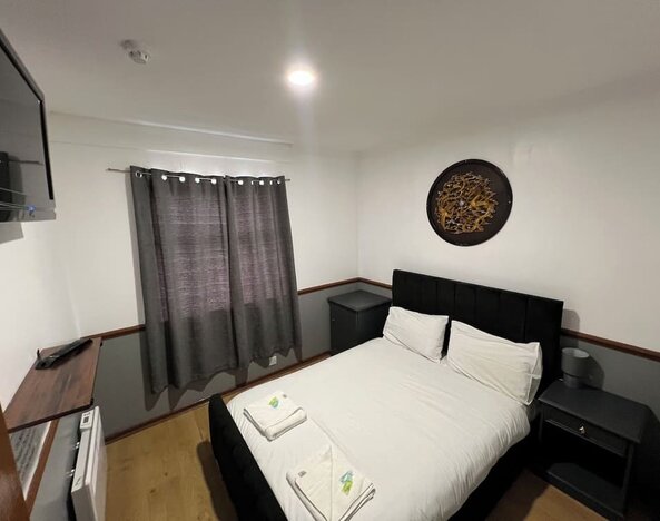 Spacious guest room with double bed, flat-screen television, and modern furnishings at Stay Inn Express.