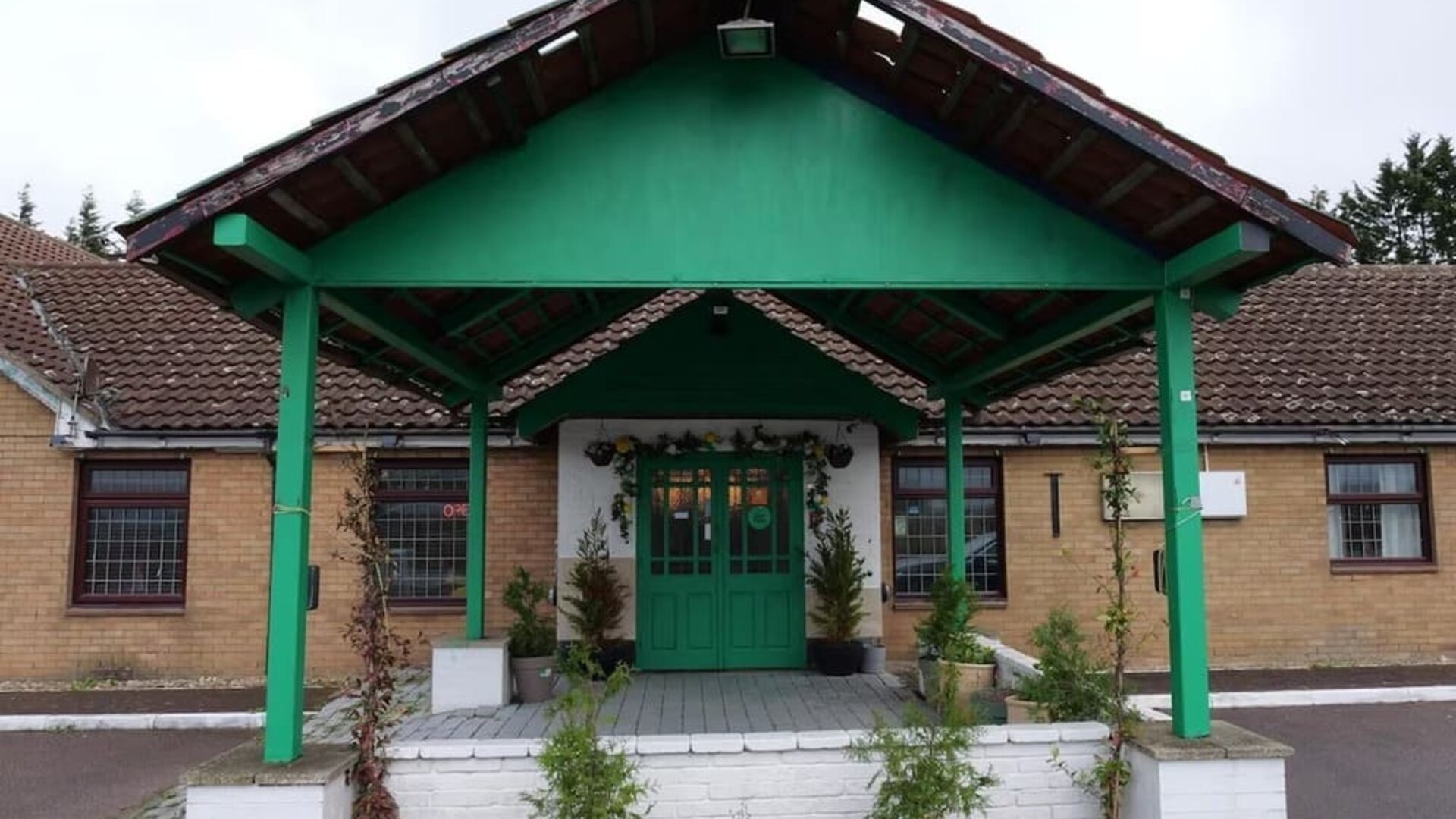 Hotel front entrance with covered porte-cochère and landscaped entrance at Stay Inn Express.