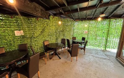 Outdoor covered seating area with tables and chairs for guest relaxation at Stay Inn Express.