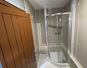 Modern bathroom with glass-enclosed shower, tiled walls, and contemporary finishes at Stay Inn Express.
