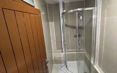 Modern bathroom with glass-enclosed shower, tiled walls, and contemporary finishes at Stay Inn Express.