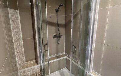 Glass-enclosed shower with modern fixtures and tiled walls at Stay Inn Express.