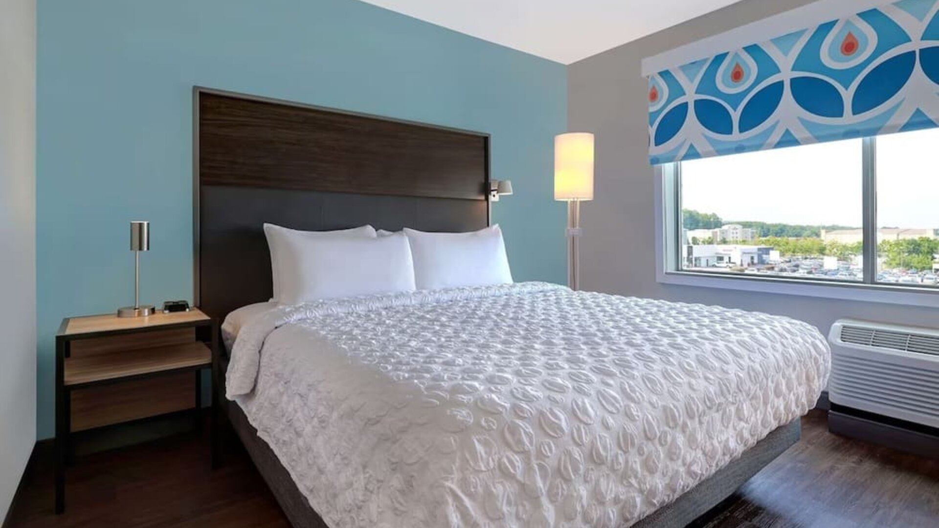King guest room with natural light, comfortable bedding, and scenic window views at Tru By Hilton Lithia Springs.