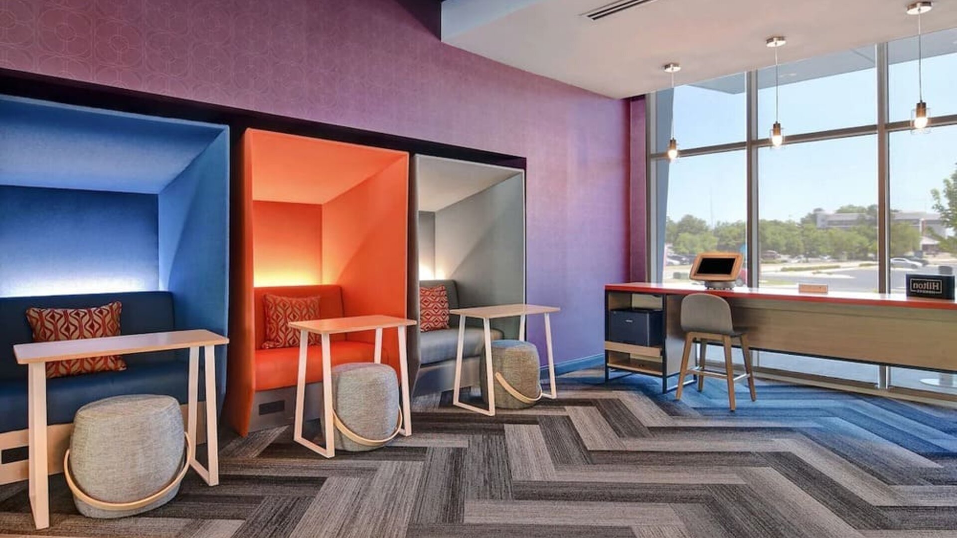 Business center with private work pods, desks, and large windows at Tru By Hilton Lithia Springs.