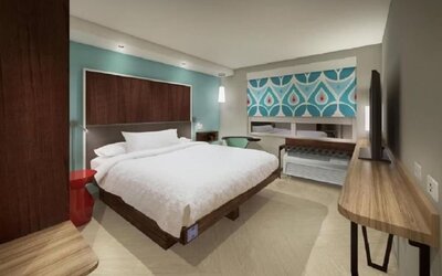 King guest room with plush bedding, work desk, and modern décor at Tru By Hilton Lithia Springs.