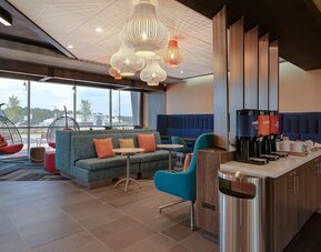 Lobby seating area with complimentary coffee station and contemporary furnishings at Tru By Hilton Lithia Springs.