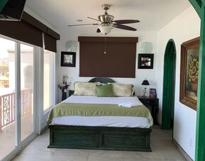 Spacious bedroom with king-size bed, private balcony, and contemporary coastal décor at Casa Playa Baja Resort.