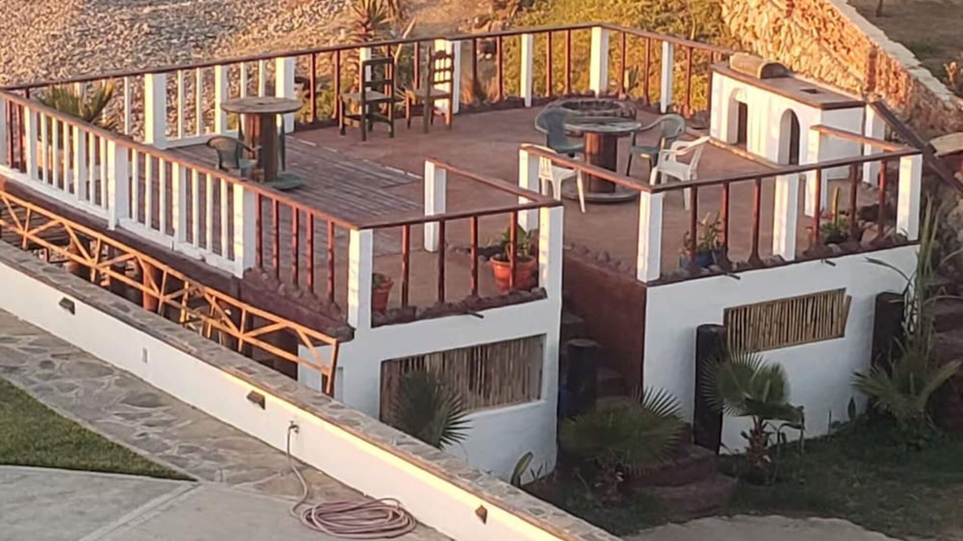 Elevated oceanfront deck with outdoor seating and fire pit overlooking the beach at Casa Playa Baja Resort.