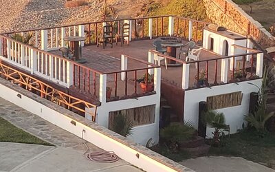 Elevated oceanfront deck with outdoor seating and fire pit overlooking the beach at Casa Playa Baja Resort.