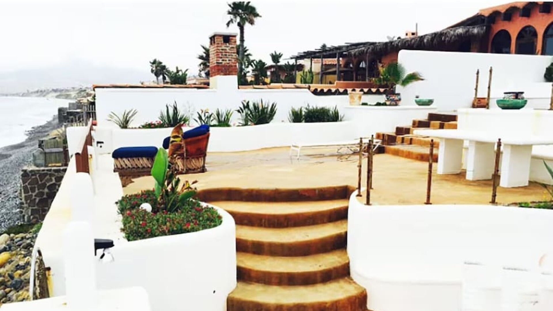 Oceanfront terrace with lounge seating, outdoor dining area, and coastal views at Casa Playa Baja Resort.