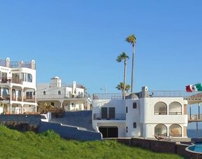 Panoramic exterior view of the beachfront resort, swimming pool, and Pacific coastline at Casa Playa Baja Resort.