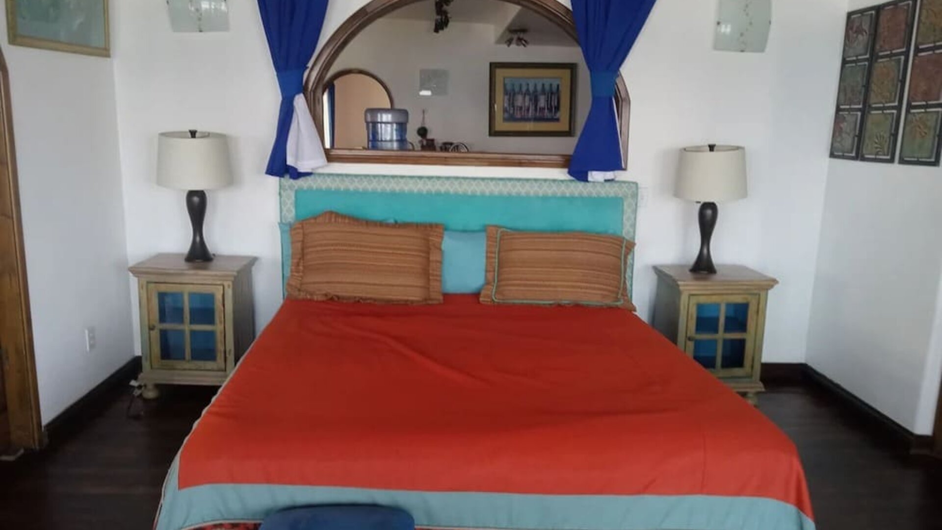 Colorful king bedroom with rustic furnishings, exposed beams, and traditional Mexican-inspired décor at Casa Playa Baja Resort.