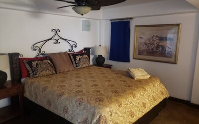 Comfortable guest bedroom with king-size bed, traditional furnishings, and warm rustic accents at Casa Playa Baja Resort.
