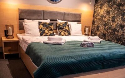 Contemporary king guest room with feature lighting and botanical wallpaper at Hotel Seven.