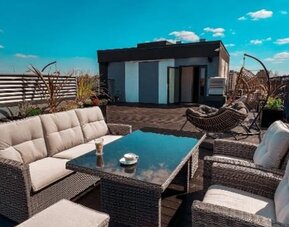 Rooftop terrace with comfortable outdoor seating and city views at Hotel Seven.