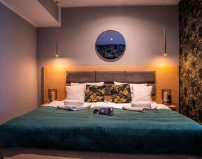 Contemporary king bedroom with feature lighting and modern furnishings at Hotel Seven.