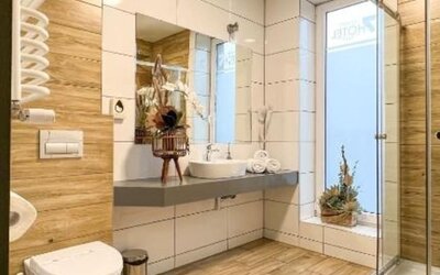 Modern hotel bathroom with walk-in glass shower, floating vanity and wood-effect tiles at Hotel Seven.