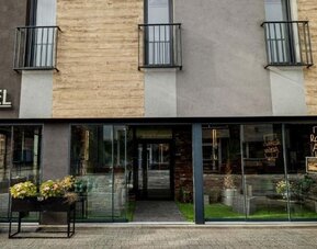 Main entrance to Hotel Seven with modern glass façade and Atelier Rozbark restaurant.