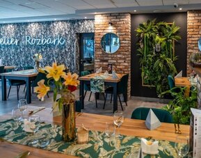 Modern hotel restaurant featuring exposed brick, greenery and elegant dining spaces at Hotel Seven.