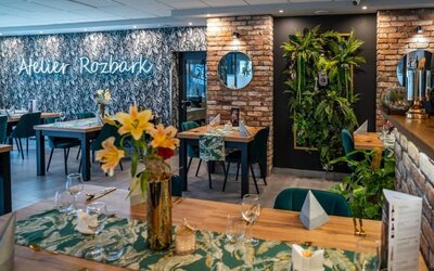 Modern hotel restaurant featuring exposed brick, greenery and elegant dining spaces at Hotel Seven.