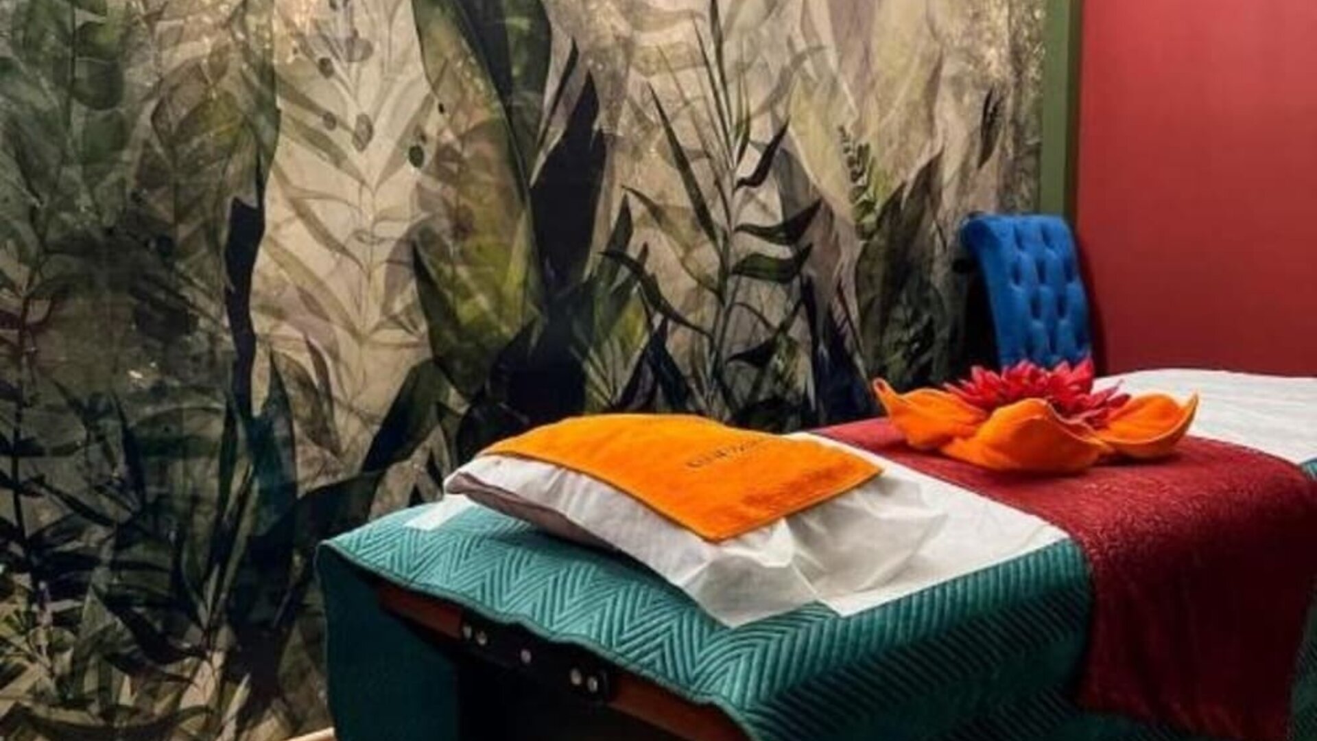 Spa treatment room with massage table, botanical mural and relaxing atmosphere at Hotel Seven.