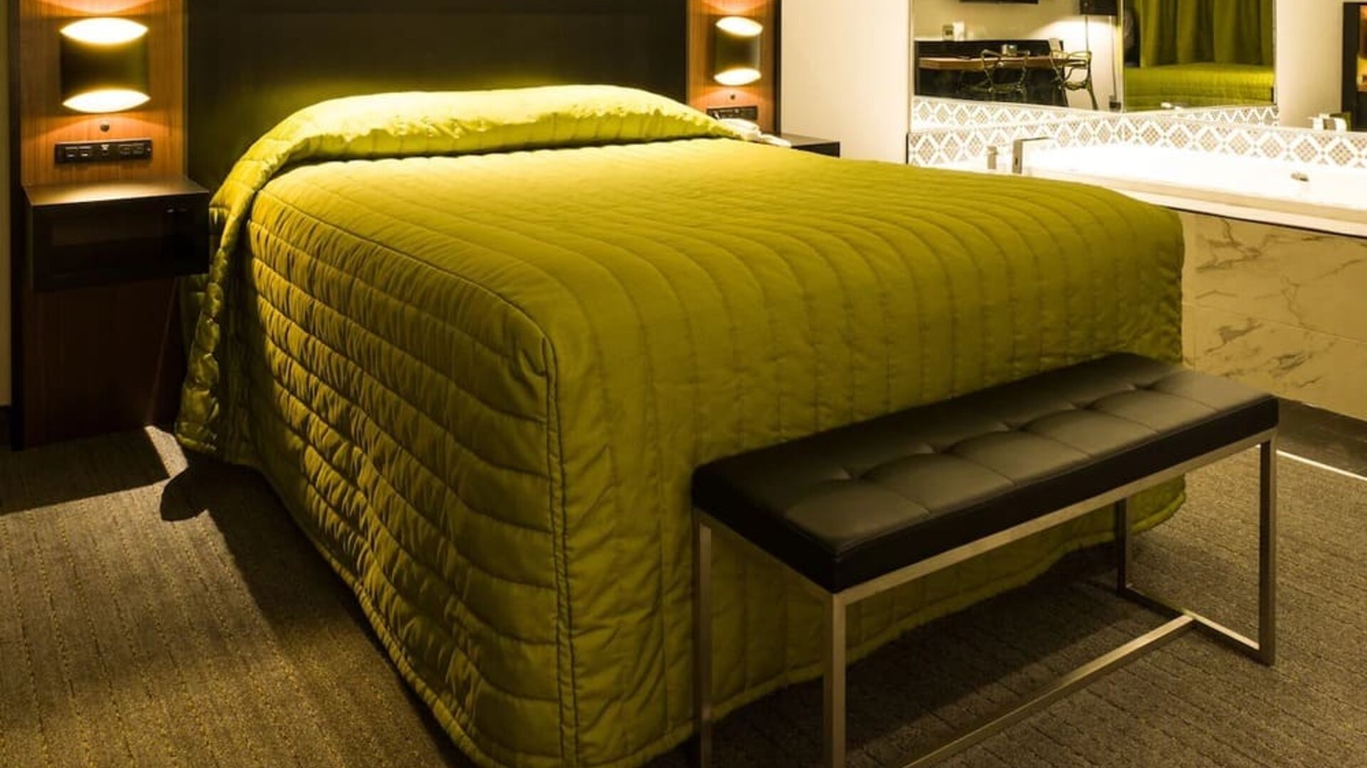 Contemporary guest room with king-size bed, open vanity and modern lighting at Le Chabrol Hotel Et Suites.