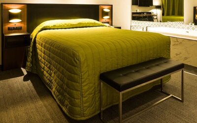 Contemporary guest room with king-size bed, open vanity and modern lighting at Le Chabrol Hotel Et Suites.
