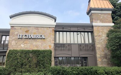 Exterior view of Le Chabrol Hotel Et Suites featuring its stone façade and main entrance.