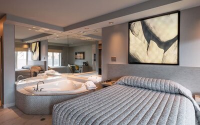 Spacious suite with king-size bed, in-room jacuzzi and contemporary décor at Le Chabrol Hotel Et Suites.