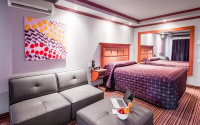 Comfortable guest room with king-size bed, seating area and modern furnishings at Le Chabrol Hotel Et Suites.