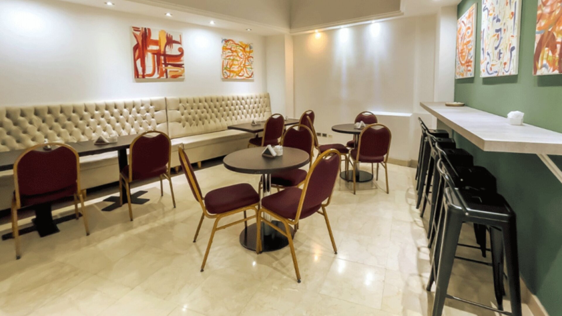 Additional dining and lounge space with café-style seating, upholstered banquettes, and contemporary artwork creating a relaxed atmosphere at HR Plaza Luxor.