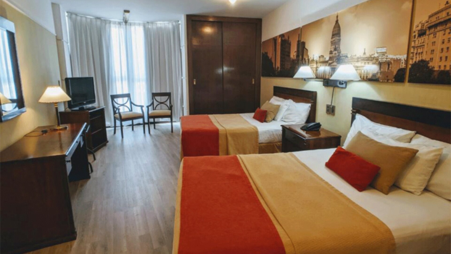 Alternative view of a guest room with two double beds, work area, flat-screen television, and warm décor designed for a comfortable stay in Buenos Aires at HR Plaza Luxor.
