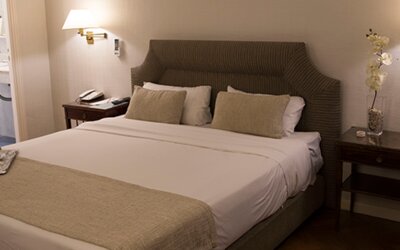 Comfortable king guest room featuring plush bedding, bedside lighting, elegant furnishings, and a spacious layout designed for rest and relaxation at Hotel Lafayette.