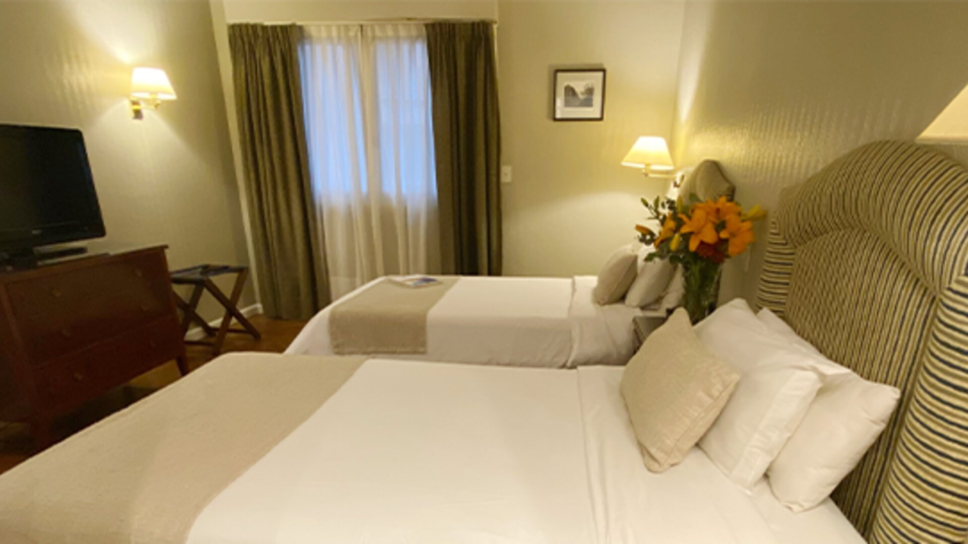 Twin guest room offering two comfortable beds, warm lighting, classic furnishings, and a relaxing atmosphere for families or friends traveling together at Hotel Lafayette.