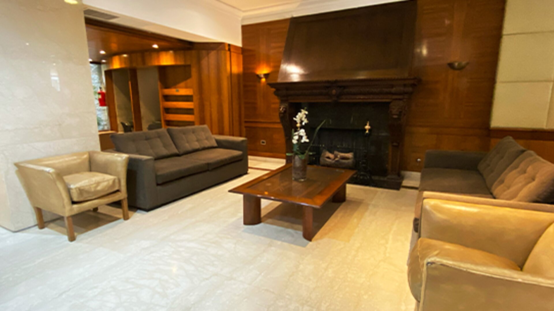 Sophisticated lounge area with comfortable sofas, armchairs, a decorative fireplace, and classic wood-paneled interiors ideal for relaxation at Hotel Lafayette.