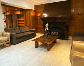 Sophisticated lounge area with comfortable sofas, armchairs, a decorative fireplace, and classic wood-paneled interiors ideal for relaxation at Hotel Lafayette.