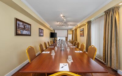 Spacious conference room with boardroom layout and audiovisual presentation facilities at Hotel Brossard.