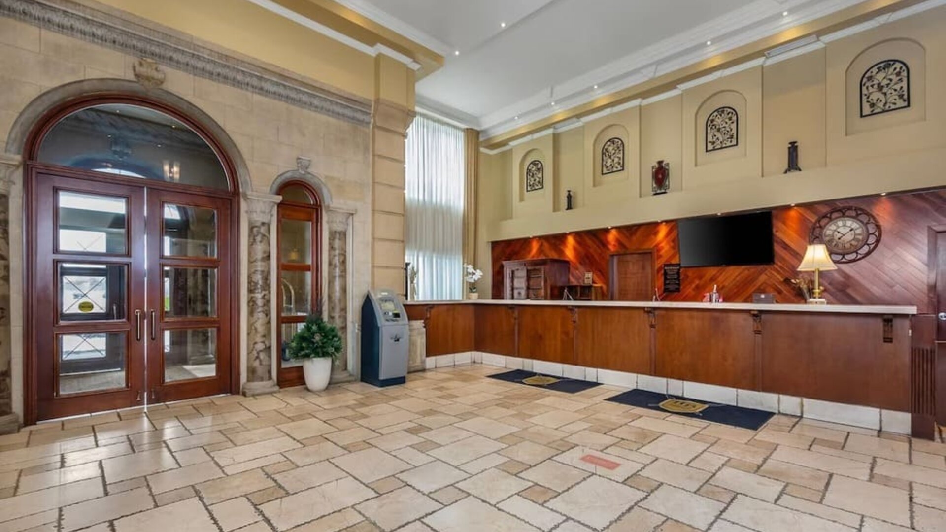 Welcoming hotel reception area with front desk and spacious lobby at Hotel Brossard.