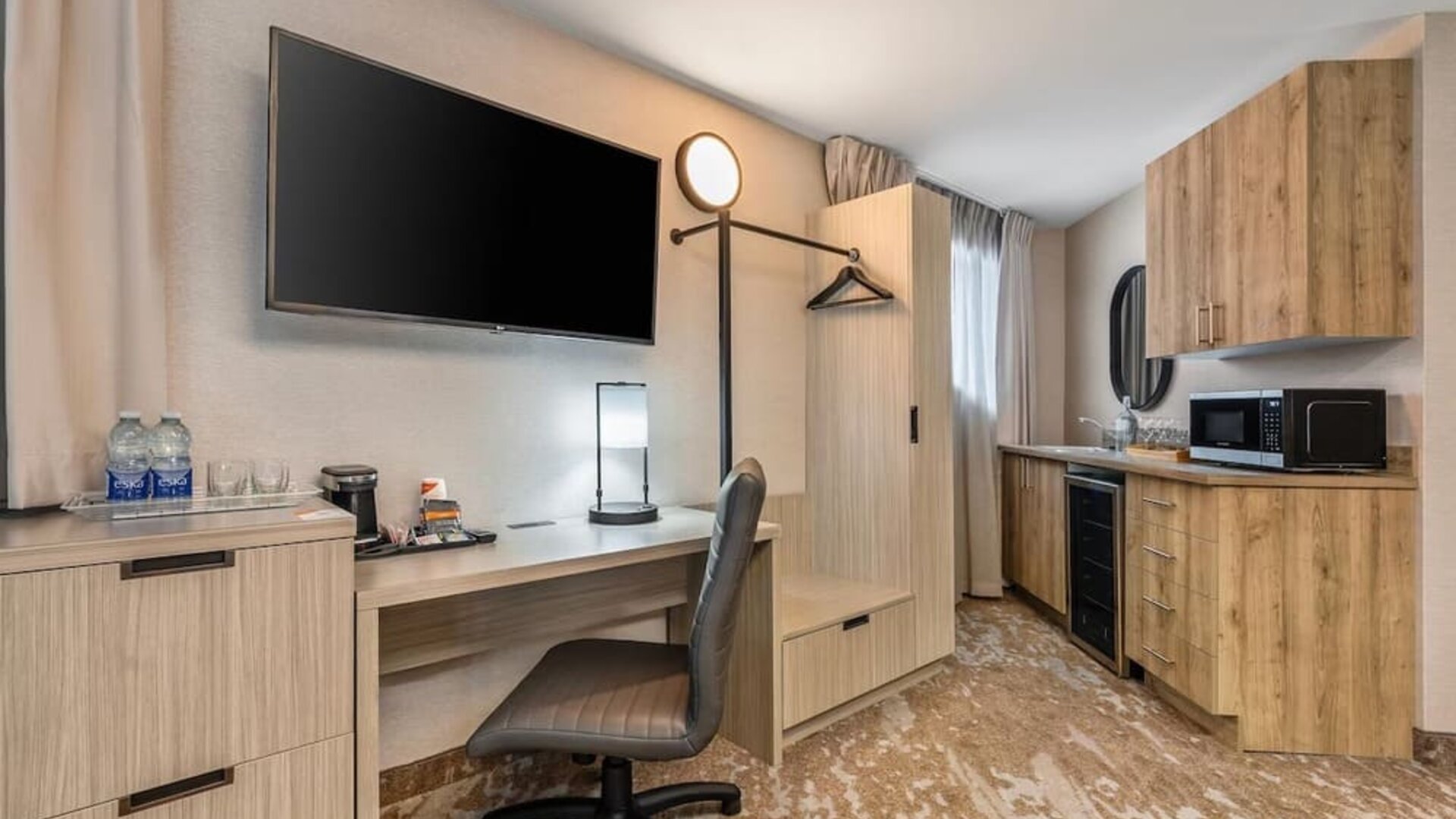 Guest room workspace with desk, kitchenette, microwave, mini fridge and coffee station at Comfort Inn Laval.